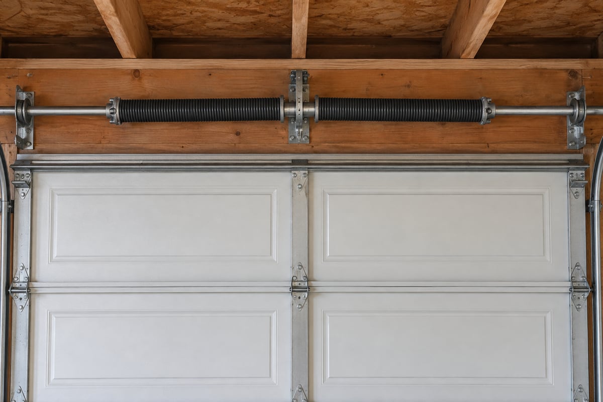 Spring assembly above a closed sectional garage door